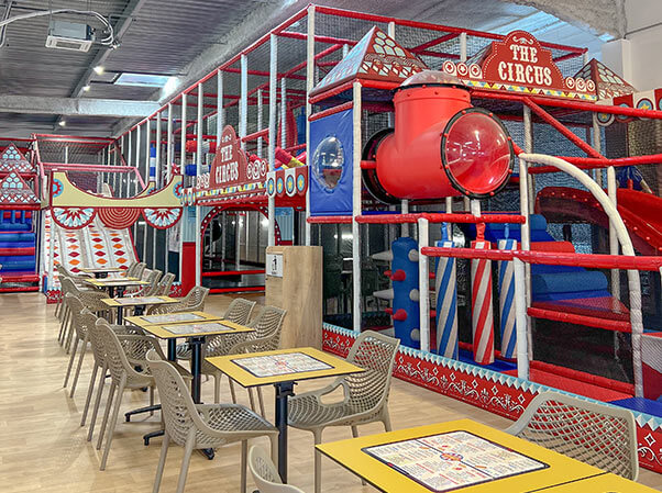 Intérieur détaillé d'une structure de jeu tubulaire multi-niveaux chez Circus Kids Vauvert, montrant des obstacles, des filets de protection et une thématique cirque vibrante réalisée par Play In Business.