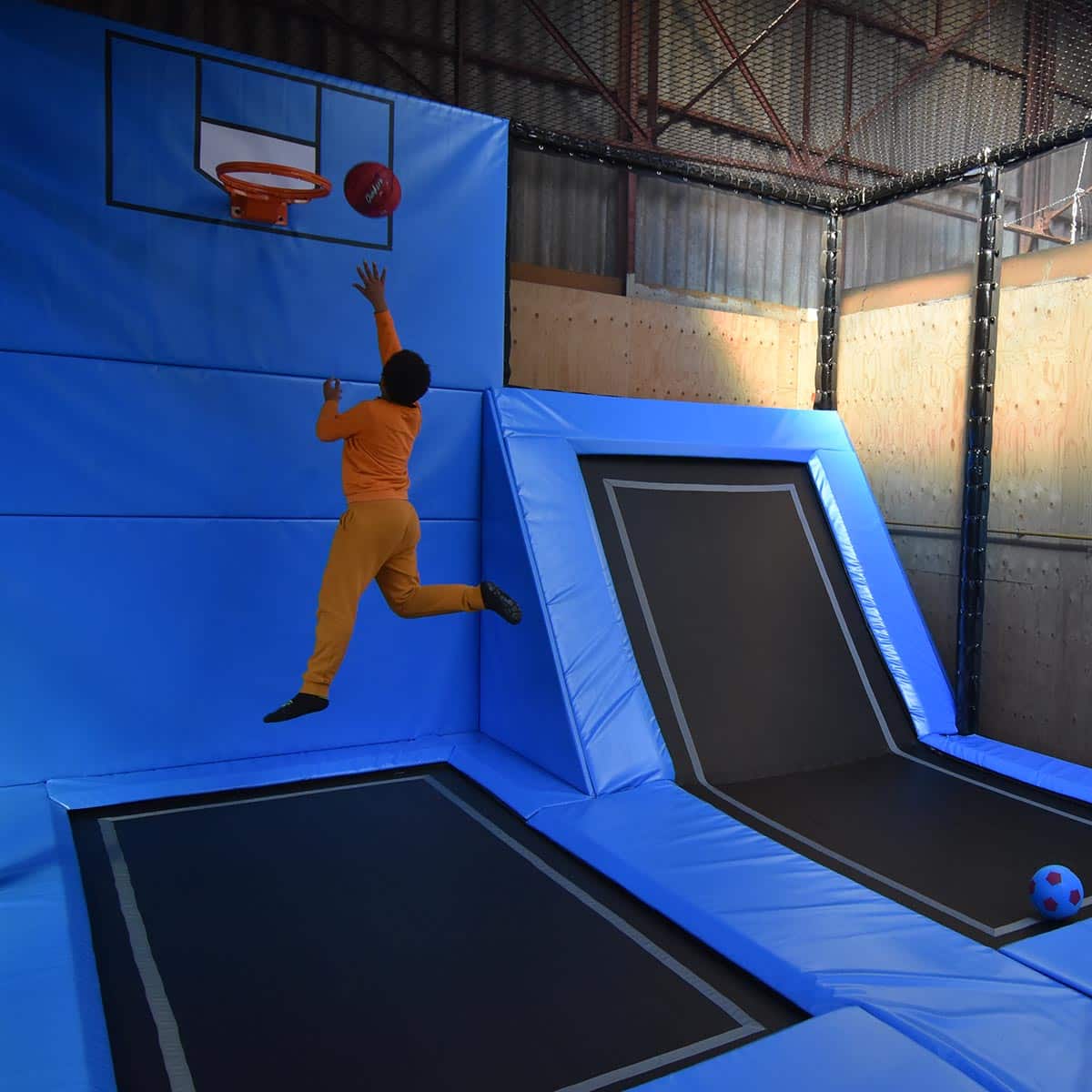 un enfant mettant un panier dans la dunk zone en bleu