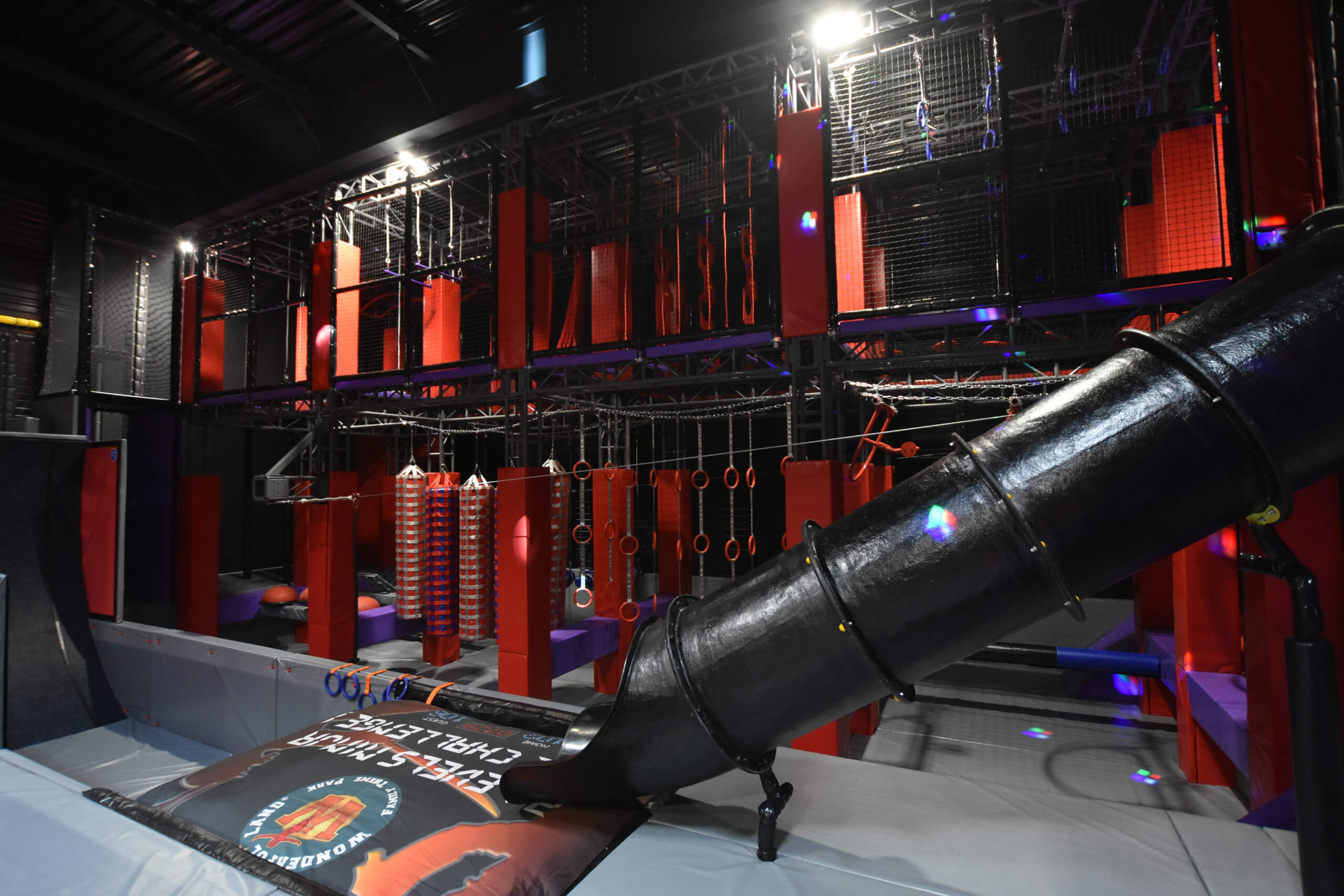 Structure de Parcours Ninja indoor sur-mesure avec obstacles suspendus, parcours d'agilité et toboggan, conçue et installée par Play In Business.