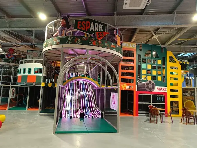 Plaine de jeux indoor sur-mesure sur le thème urbain avec grand toboggan lumineux multi-pistes, conçue et installée par Play In Business pour le complexe Espark 23 à Ancenis.