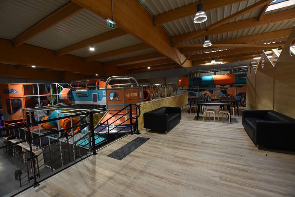 Plaine de jeux tubulaire pour enfants sur le thème de l'espace avec espace détente au premier plan, conçue et installée sur mesure par Play In Business au complexe Fun Space à Sens.