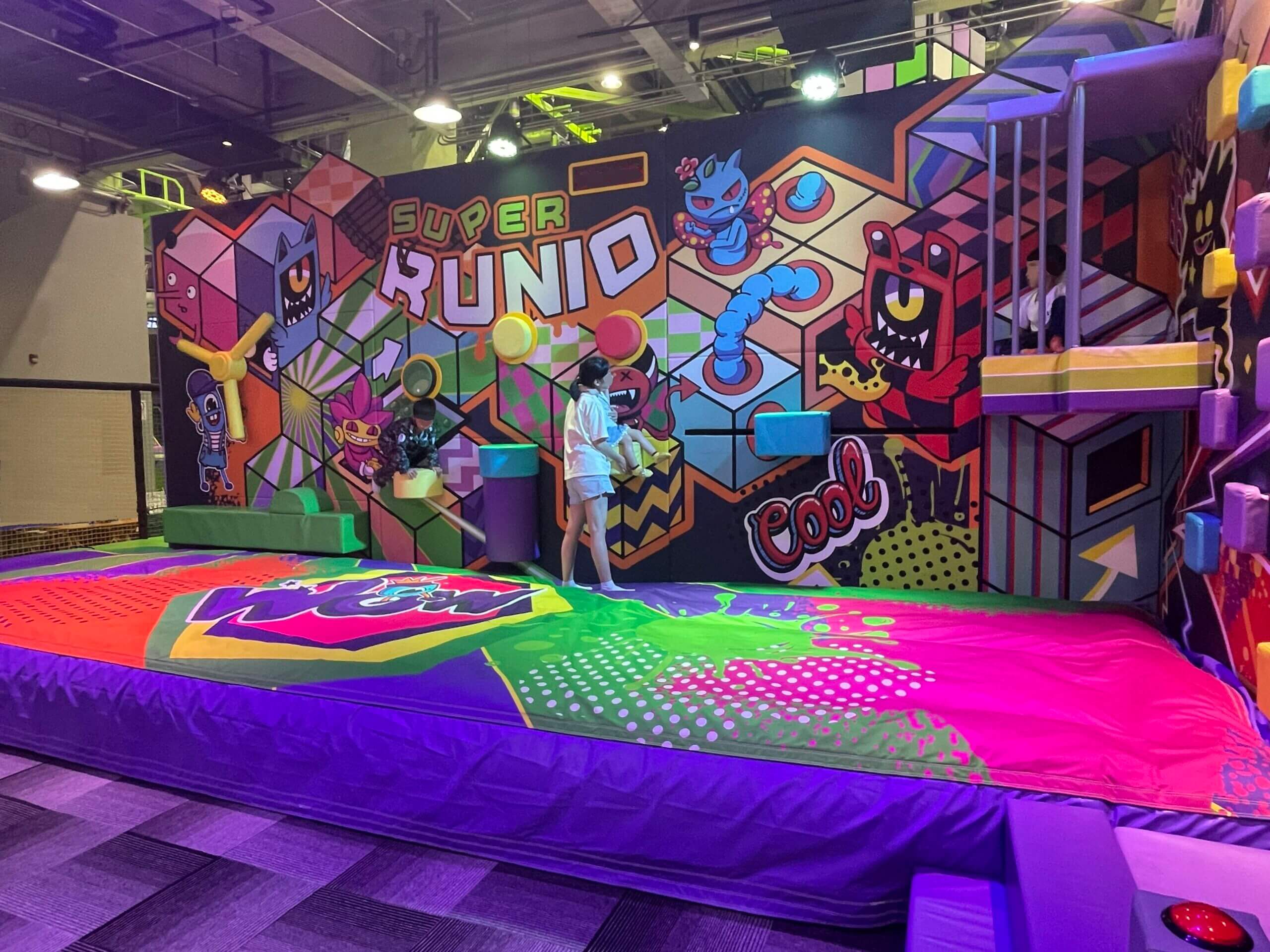 Vue aérienne spectaculaire de la structure tubulaire géante 'Super Runio', une aire de jeux indoor sur plusieurs niveaux conçue et aménagée par Play In Business.