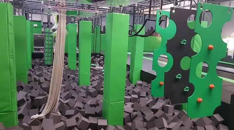 green and gray ninja course with various obstacles