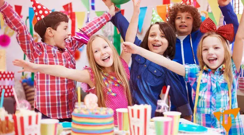 several children attending a birthday party around a cake