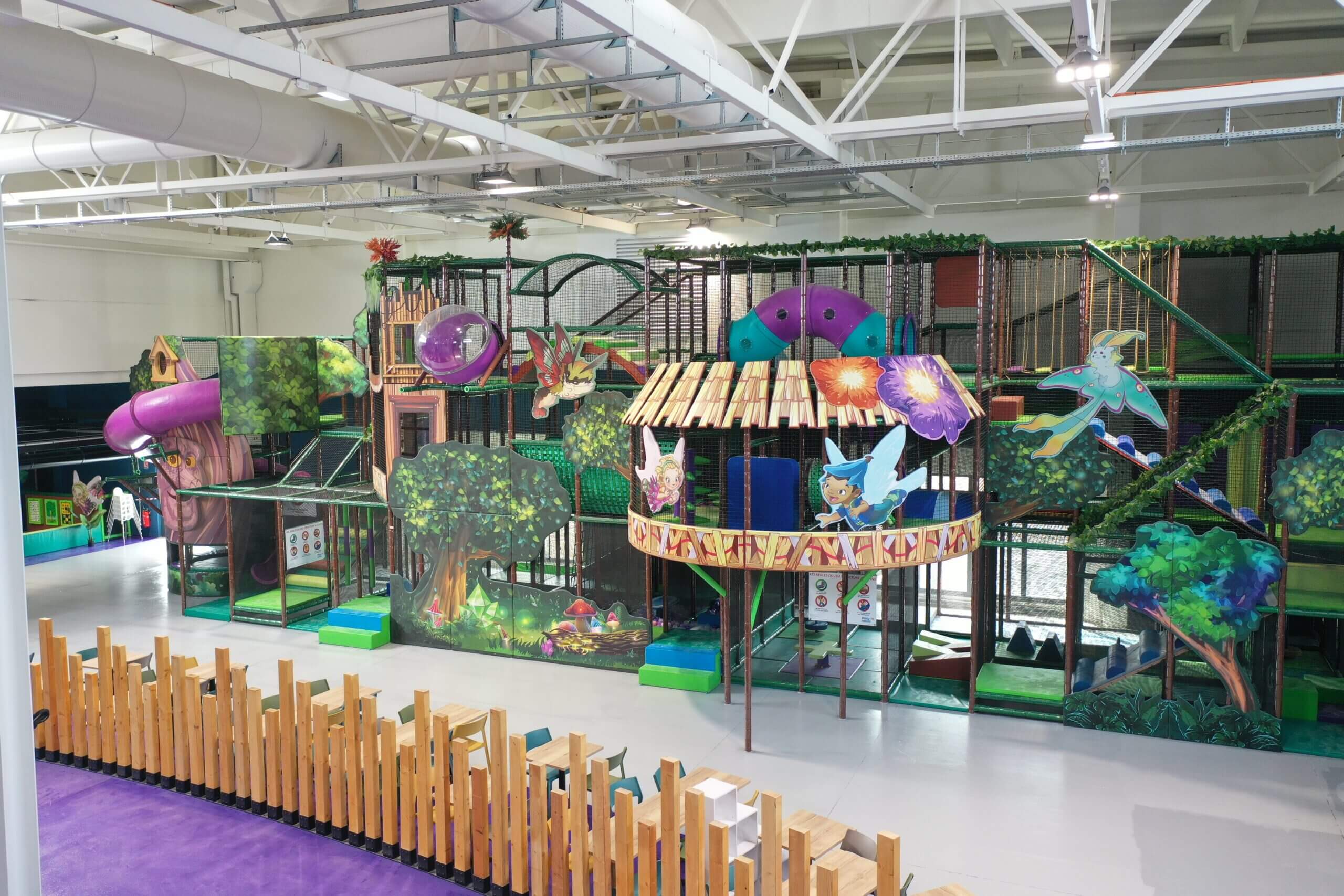 Vue aérienne spectaculaire d'un immense parc de jeux multi-activités indoor réalisé sur mesure par Play In Business.