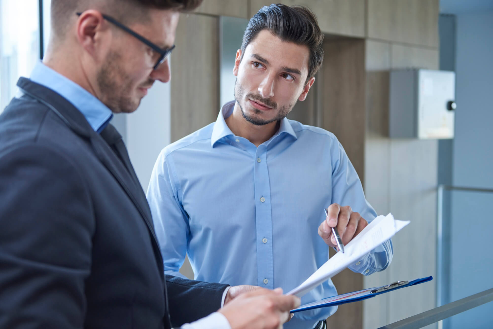 Deux professionnels étudiant un dossier financier, illustrant l'accompagnement de Play In Business pour garantir la rentabilité de votre futur parc de loisirs.