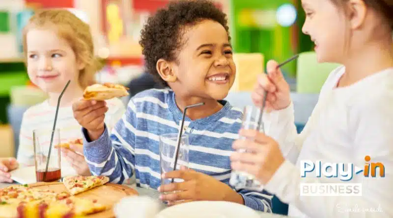 children eating a snack around a table.