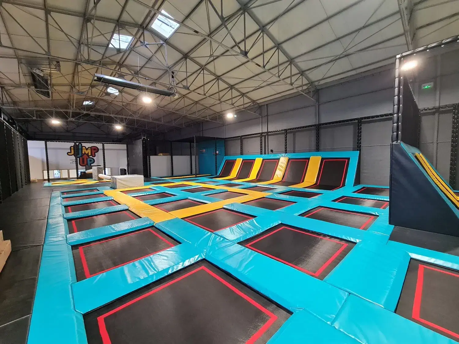 Vue panoramique du Trampoline Park Jump Up à Cherbourg avec une grande zone de saut principale, des dalles de sol orange et des cibles interactives, conçu et installé par Play In Business.