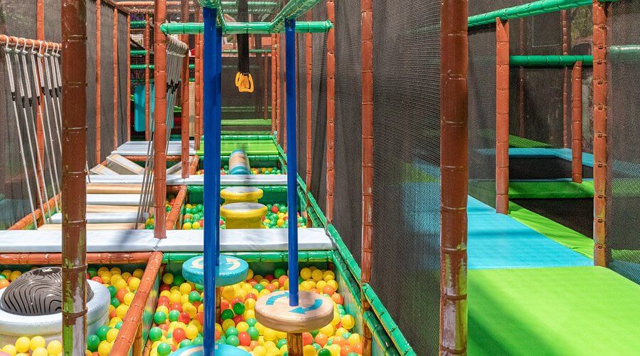 Parcours d'aventure pour enfants avec piscine à balles et obstacles d'équilibre, aménagement Play In Business au parc Wonderful-Land.
