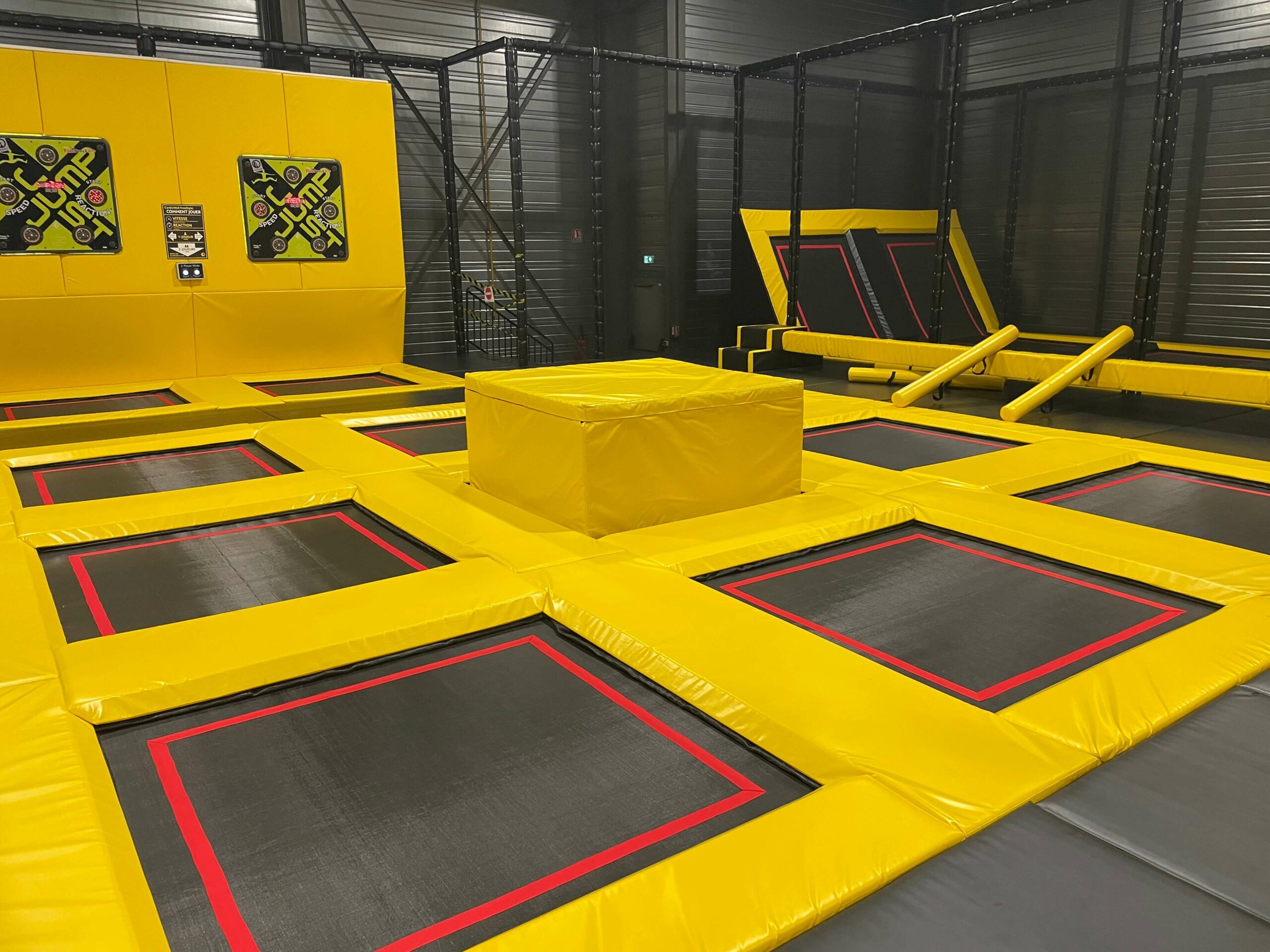 Zone de sauts principale du parc Just Jump à Marnaz par Play In Business, incluant des trampolines interconnectés et des cibles de jeu interactives sur mur de frappe.