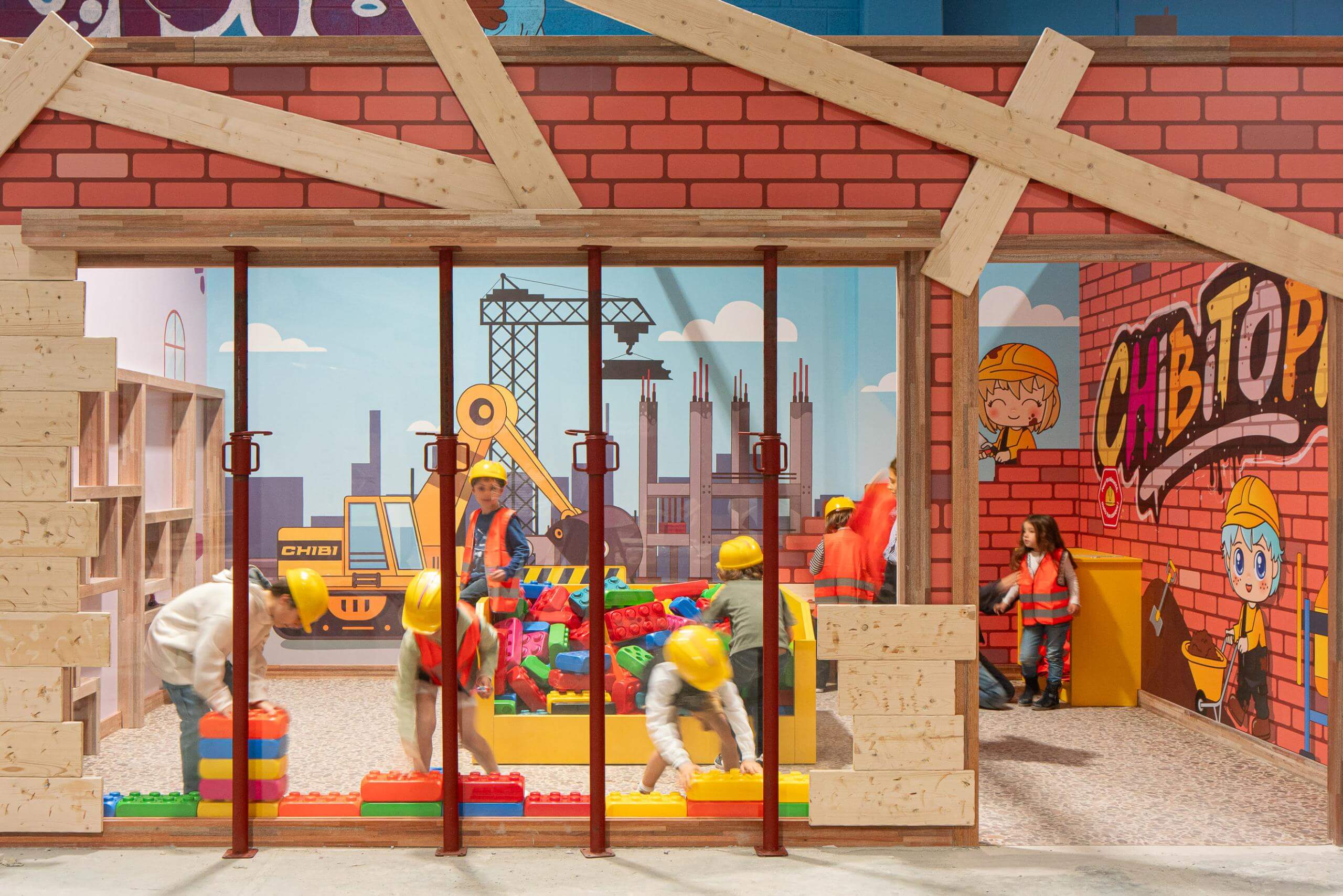 Jeu d'imitation espace chantier avec briques de construction géantes et décors pour parc de loisirs indoor.