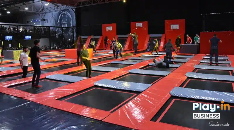 people jumping in a trampoline park. With a basketball zone integrated into the trampoline.